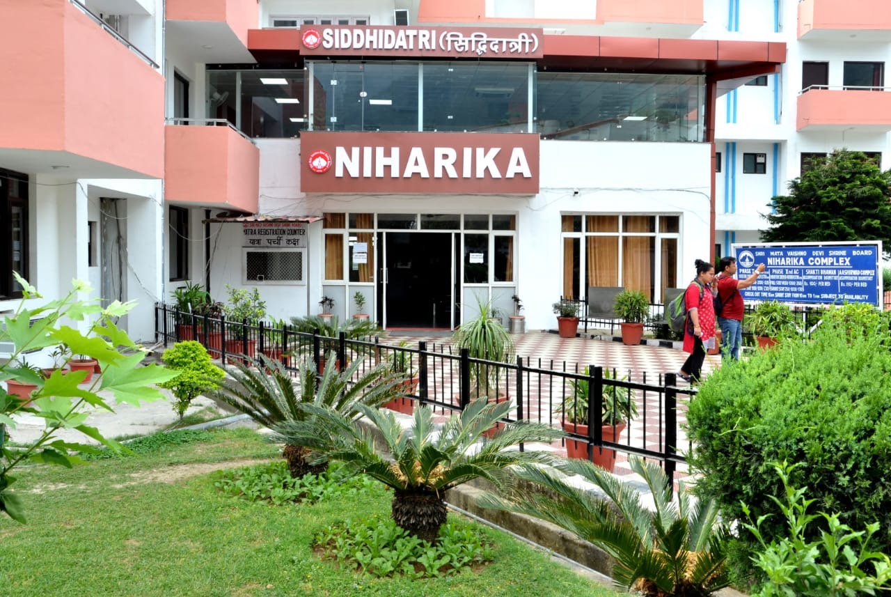 Niharika Bhavan Katra hotel exterior with Himalayan foothills at golden hour